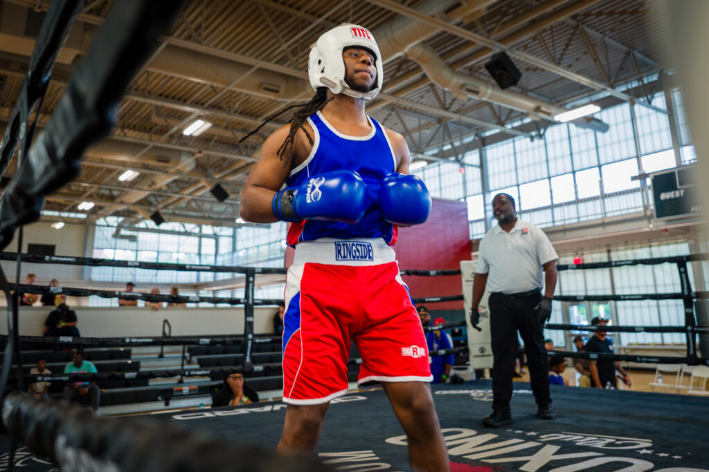 Amateur boxer in blue and red gear standing in a boxing ring