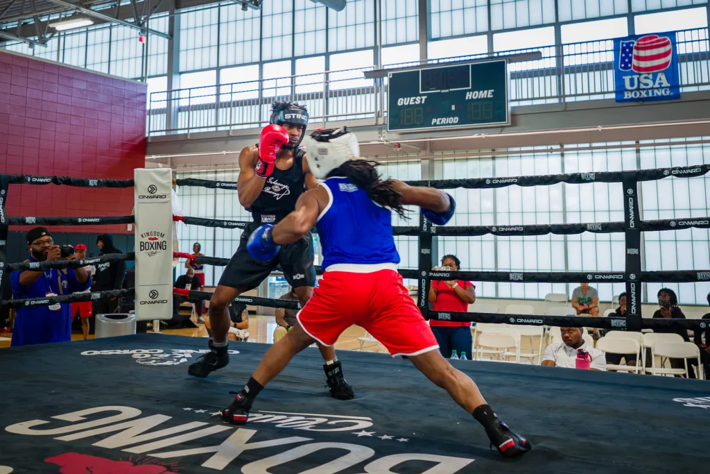Two amateur boxers trading punches in a USA Boxing ring