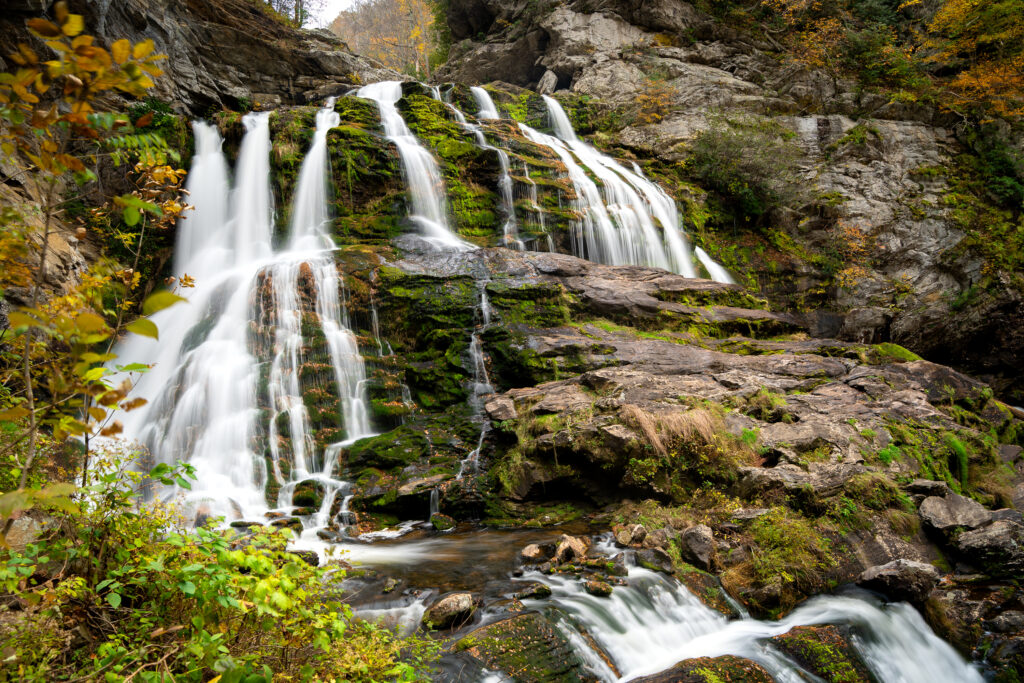 Cullasaja Falls cascading over mossy rocks surrounded by autumn foliage