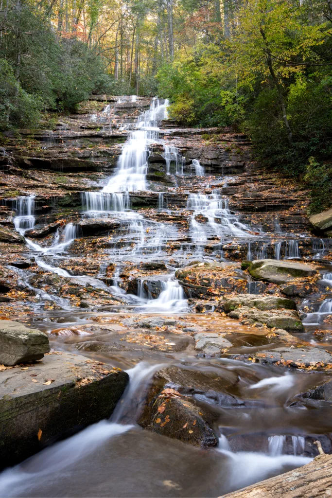 Tiered Minnehaha Falls cascading over rock ledges surrounded by autumn foliage