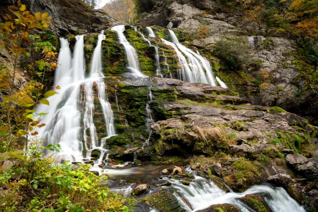 Cullasaja Falls cascading over mossy rocks surrounded by autumn foliage