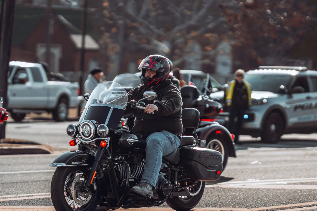 Motorcyclist on black cruiser bike riding through city street traffic