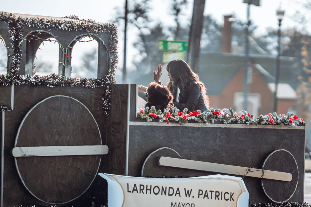 Parade float decorated for the holidays with Mayor Larhonda W. Patrick banner