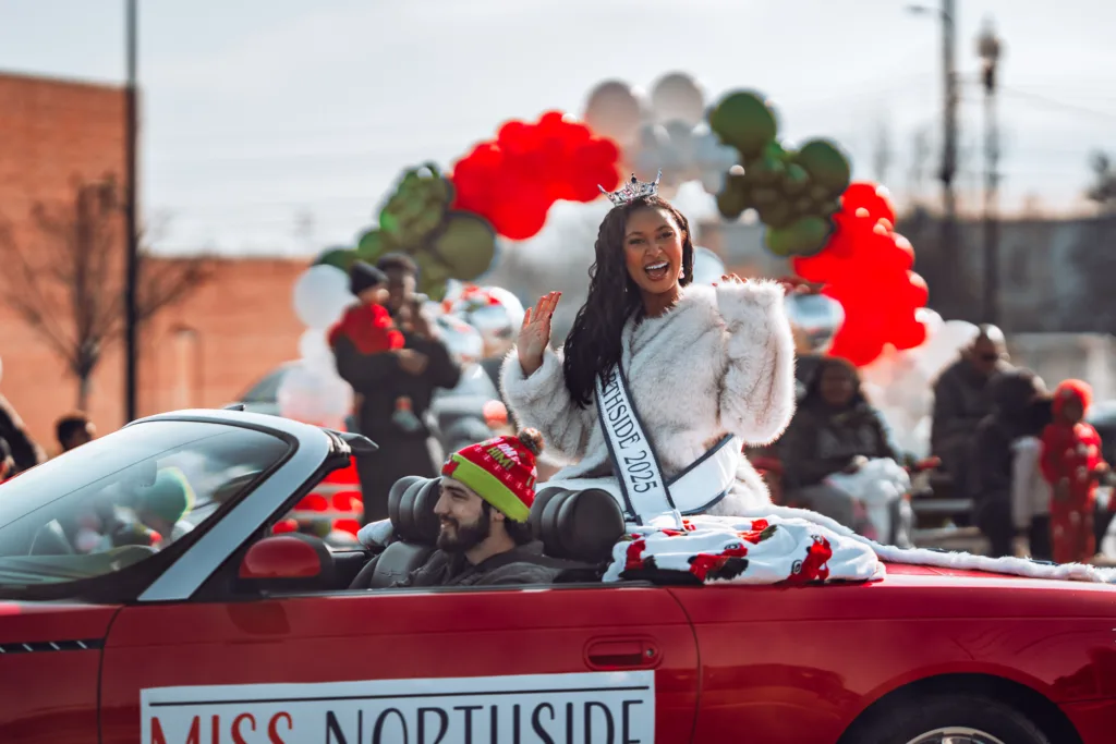 Miss Northside 2023 waving from red convertible in holiday parade