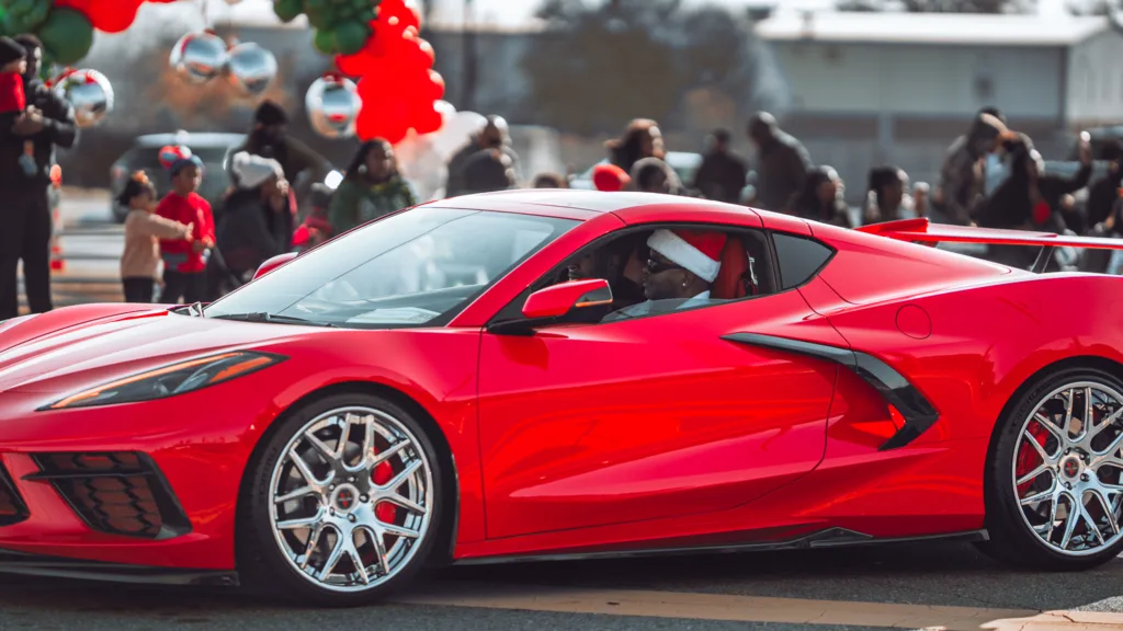Bright red sports car driving in a festive holiday parade