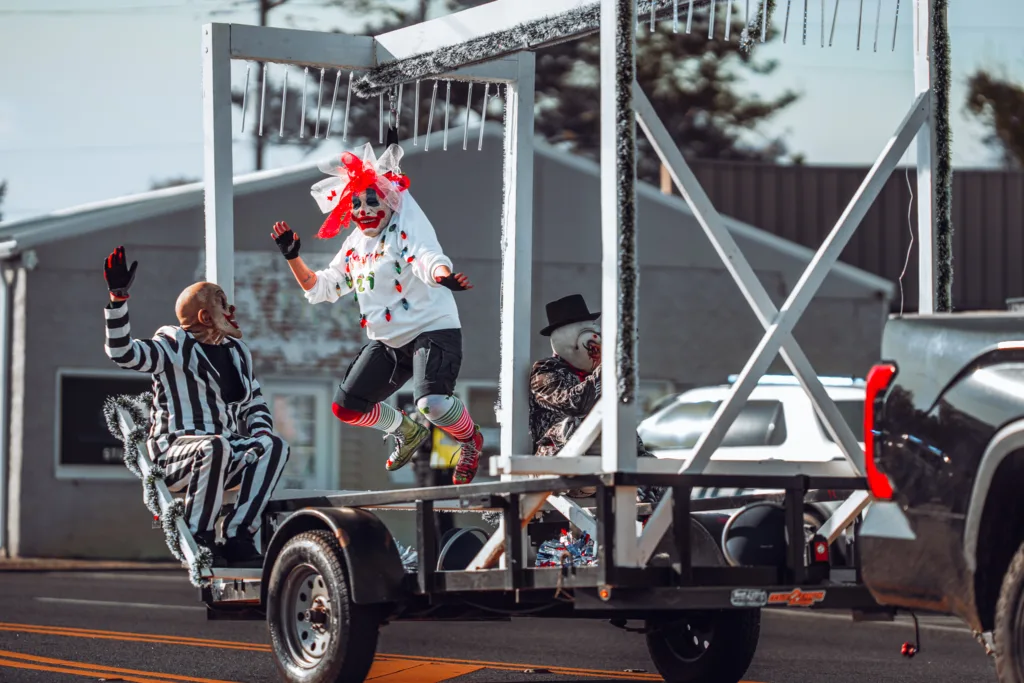 Colorful clowns performing on a small decorated parade float on the street