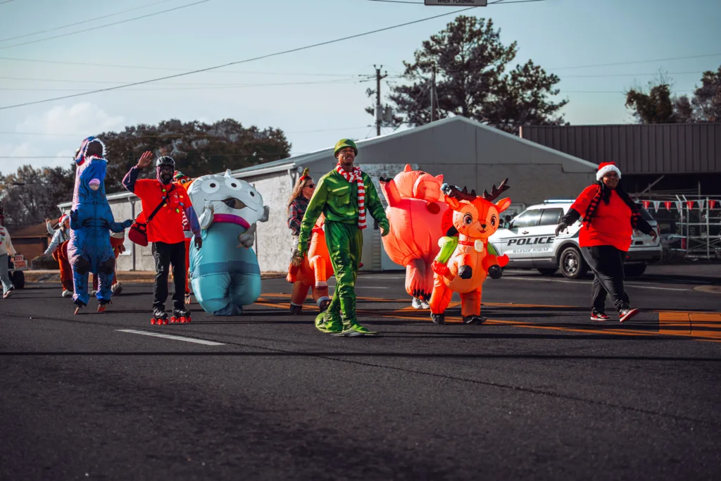 People in bright inflatable holiday costumes walking in a street parade
