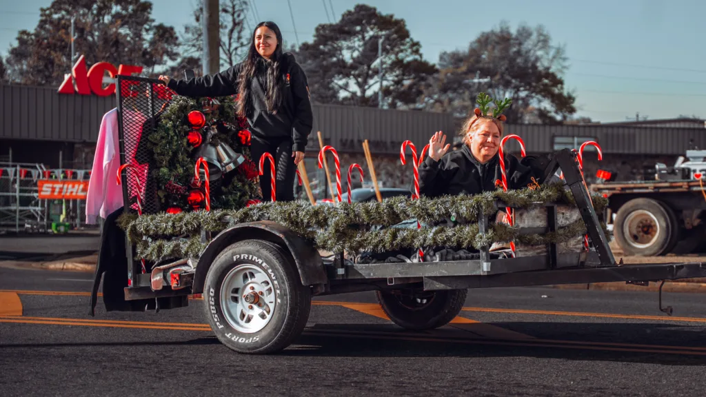 Kids on decorated trailer with candy canes during holiday parade