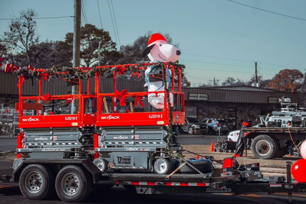 Red Skyjack lifts on trailer decorated for Christmas parade