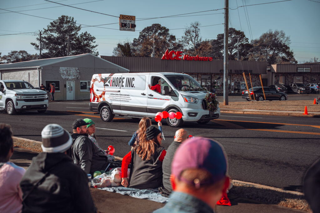HOPE INC decorated van drives past spectators at a community parade