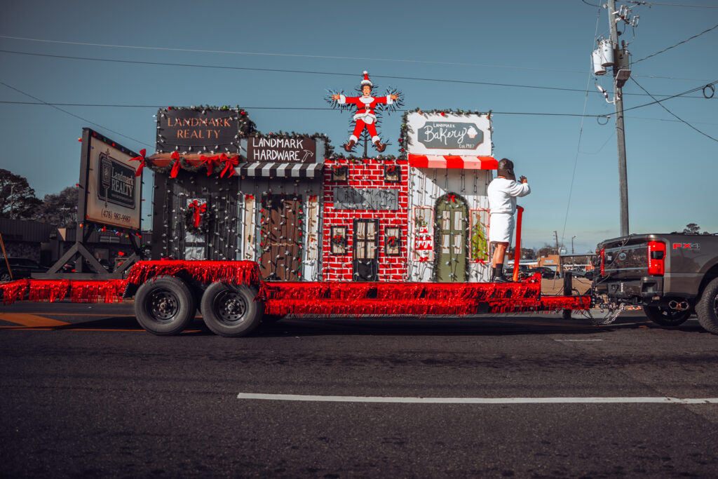 Colorful Christmas parade float decorated as small town storefronts