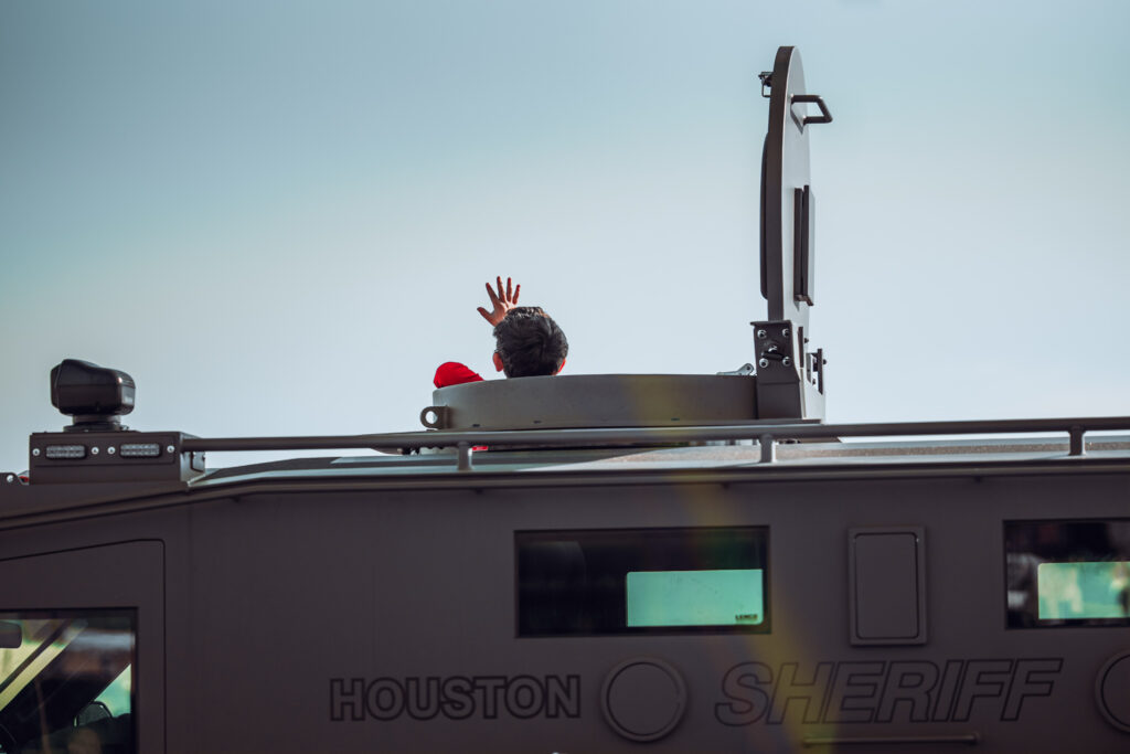 Person waving from hatch of Houston Sheriff armored vehicle