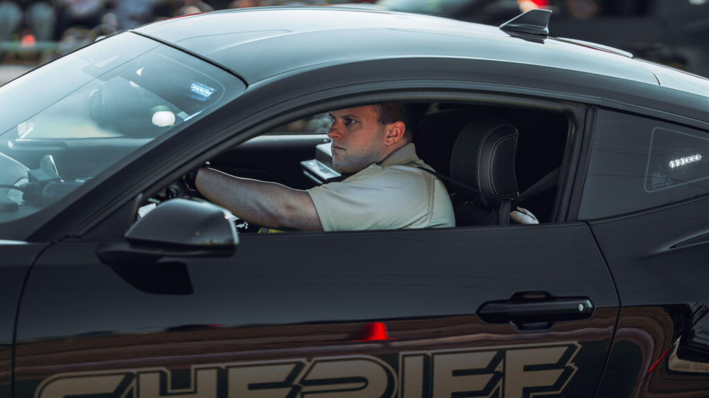 Sheriff deputy in black patrol car looking ahead while driving