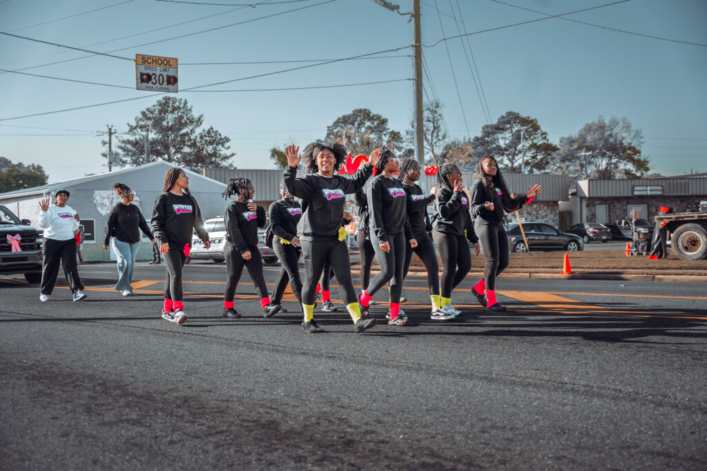 Youth dance team in matching outfits performing in a street parade