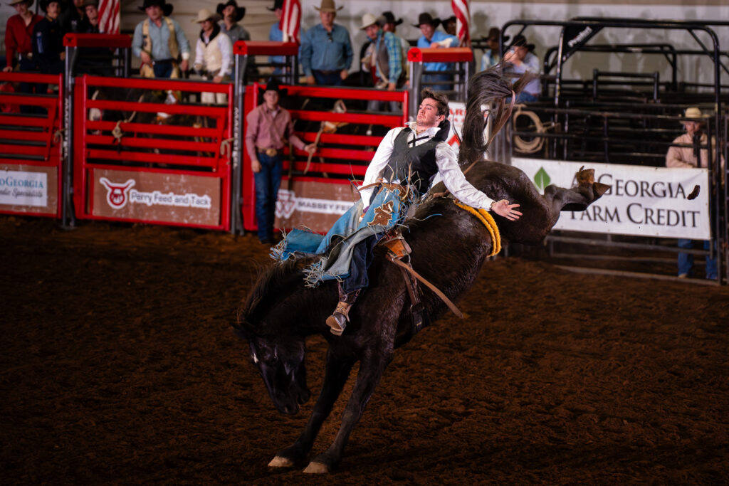 Cowboy riding a bucking horse during a bareback bronc rodeo event